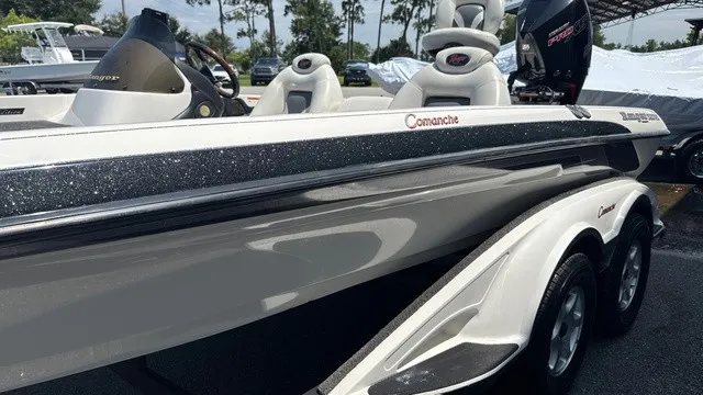 Slide: The Image of A 2005 Ranger 520 VX Comanche with two seats and an outboard motor, on a trailer. - 6