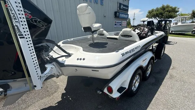 Slide: The Image of A white 2005 Ranger 520 VX Comanche boat on a trailer, parked outside a building. - 3