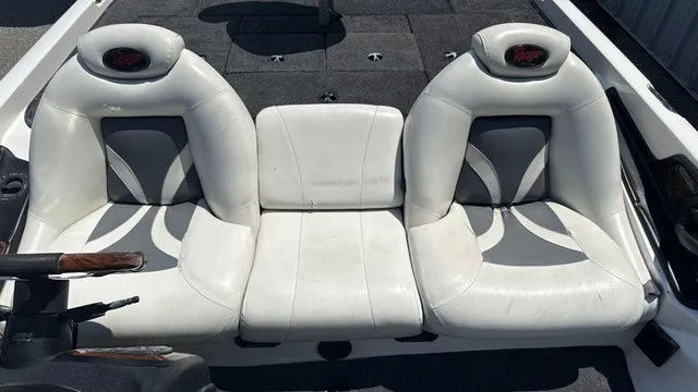 Slide: The Image of Two white cushioned seats with gray accents on a boat, surrounded by dark carpet flooring. - 13