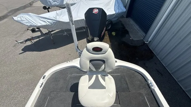 Slide: The Image of A 2005 Ranger 520 VX Comanche with a seat on the deck and a motor at the back. - 16