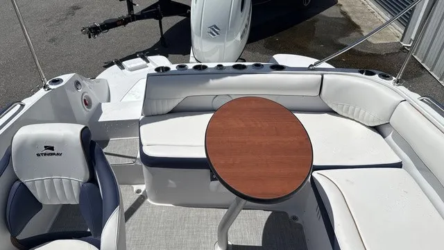 Slide: The Image of The image shows the cockpit of a Stingray 192 SC boat with white upholstery and a round wooden table. - 12