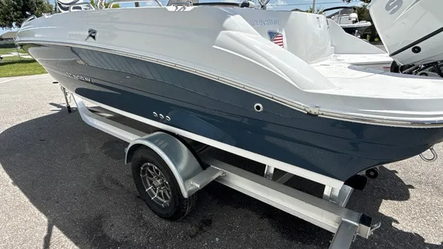 Slide: The Image of A modern 2027 Stingray 192 SC on a trailer, featuring a blue hull and white deck. - 4