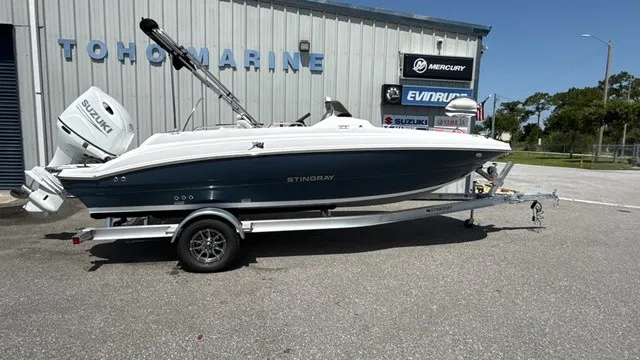 The Image of A white Stingray 192 SC boat on a trailer in front of a building. - 1