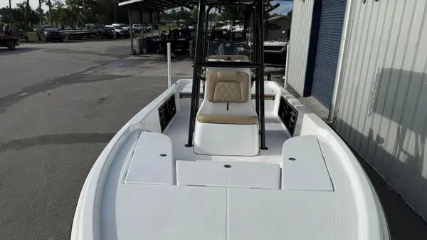 Slide: The Image of A modern boat with an open deck and central console, parked in a marina area. - 8