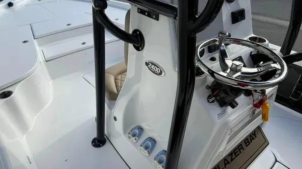 Slide: The Image of The image shows the helm of a Blazer PureBay 2400 boat with a modern steering wheel. - 14