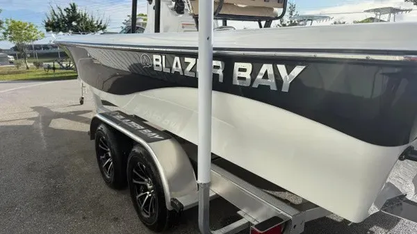 Slide: The Image of A 2026 Blazer PureBay 2400 on a trailer. The boat features a sleek design. - 7