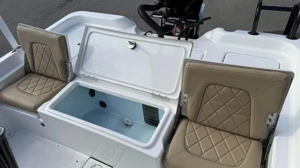 Slide: The Image of The image shows the interior of a Blazer PureBay 2400 boat with beige seats and an open storage compartment. - 13
