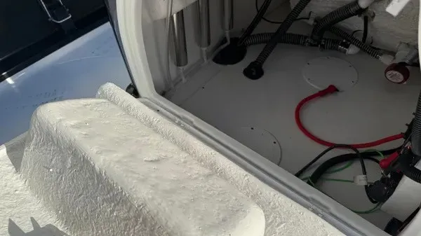 Slide: The Image of An open storage compartment in the boat reveals cables and connections. - 23