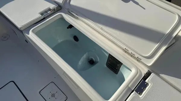 Slide: The Image of An open storage compartment on a boat with a white deck and hinges. - 27