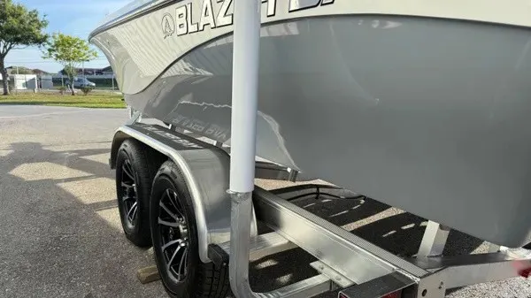 Slide: The Image of A 2026 Blazer PureBay 2200 boat on a trailer with black wheels. - 9