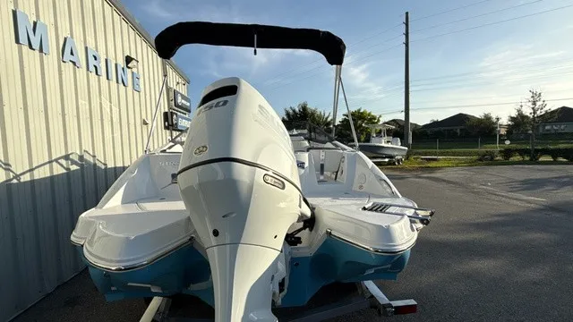 Slide: The Image of A 2027 Stingray 211 DC boat on a trailer beside a building. The engine is visible. - 4