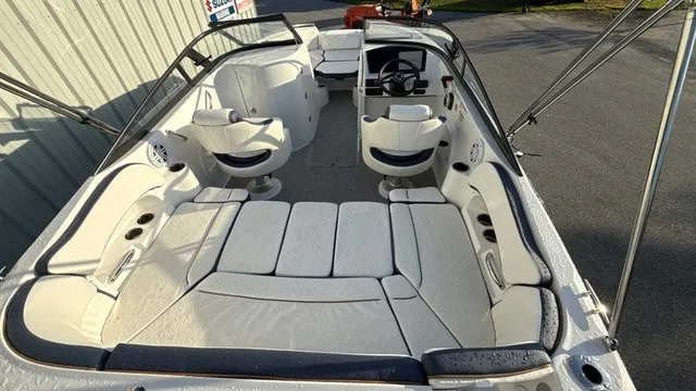 Slide: The Image of The image shows the interior of a 2027 Stingray 211 DC boat with white upholstery and a helm. - 7