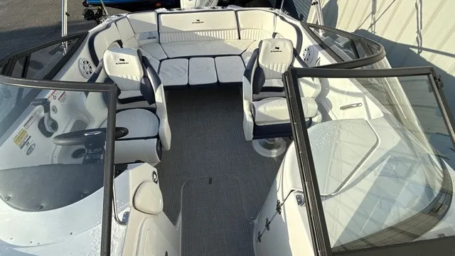 Slide: The Image of The image shows the cockpit of a 2027 Stingray 211 DC boat with white seating and glass windows. - 15