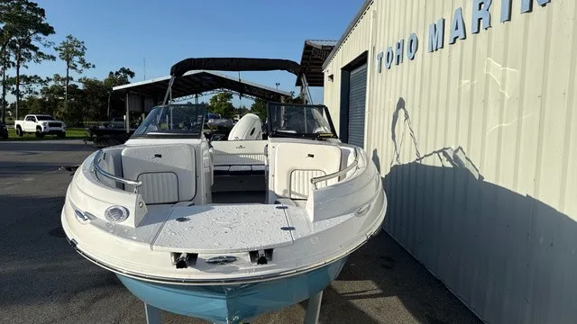 Slide: The Image of A modern 2027 Stingray 211 DC is parked outside a building. It features an open deck and white exterior. - 6