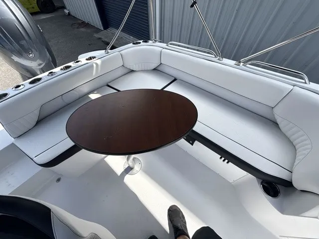 Slide: The Image of The image shows the seating area of a Stingray 212 SC boat with a round table. - 15