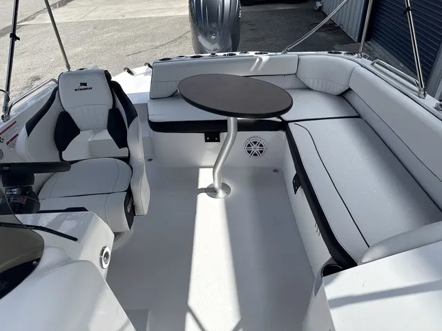 Slide: The Image of The image shows the cockpit of a 2027 Stingray 212 SC boat with white upholstery and a round table. - 11
