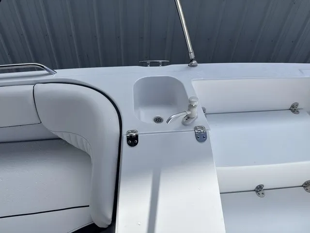 Slide: The Image of The image shows the white deck of a Stingray 212 SC boat with seating and a sink. - 16