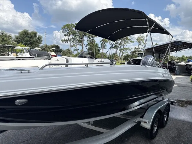 Slide: The Image of The image shows a 2027 Stingray 212 SC boat with a black hull and sunshade. - 6
