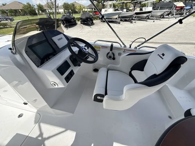 Slide: The Image of The image shows the cockpit of a Stingray 212 SC boat with a modern helm and comfortable seating. - 12