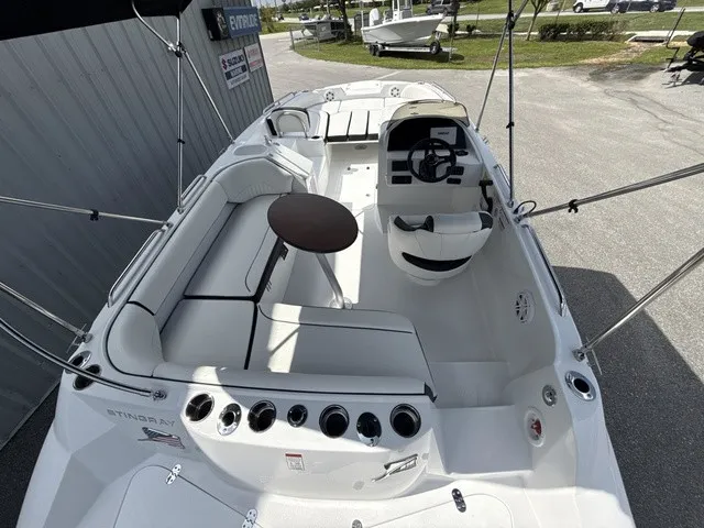 Slide: The Image of The image shows the cockpit of a 2027 Stingray 212 SC boat with white seating and a round table. - 7