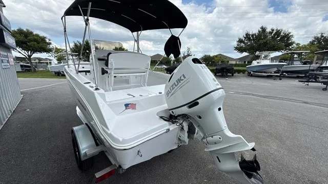 Slide: The Image of A white boat with a Suzuki outboard motor on a trailer. It features a black sunshade. - 5