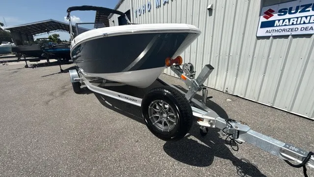 Slide: The Image of A 2027 Stingray 172 DC boat on a trailer, parked beside a building. - 6
