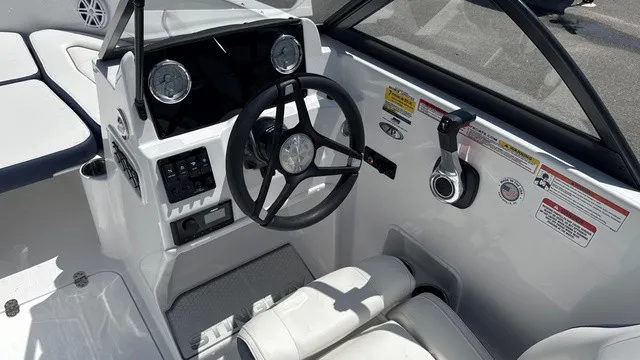 Slide: The Image of The image shows the cockpit of a Stingray 172 DC boat. It features a modern steering wheel and instruments. - 9