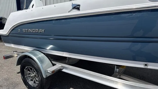Slide: The Image of A blue and white 2027 Stingray 172 DC on a trailer. - 2