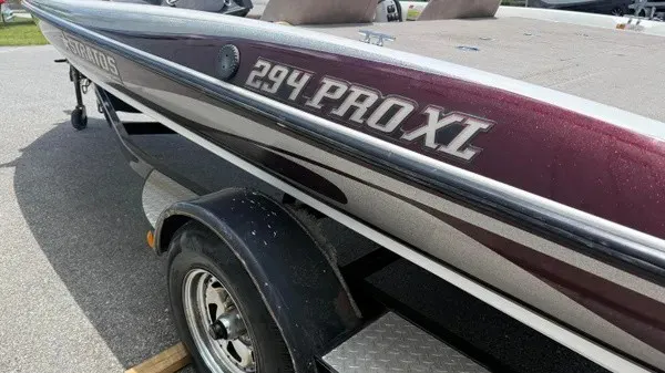 Slide: The Image of A 2006 Stratos 294 Pro XL boat with a dark red hull and silver accents on a trailer. - 6