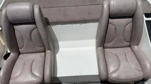 Slide: The Image of Two gray boat seats with padded backs and seats, mounted on a white deck. - 13