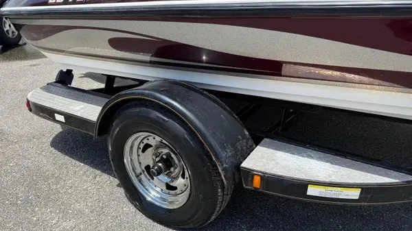 Slide: The Image of A 2006 Stratos 294 Pro XL boat on a trailer, featuring shiny rims and in good condition. - 2