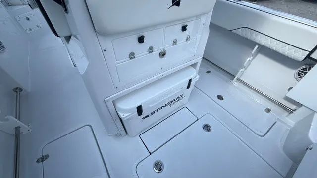 Slide: The Image of The image shows the cockpit of a Stingray 253 CC boat with storage and seating. - 20