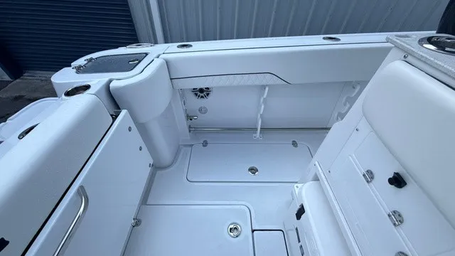 Slide: The Image of The image shows the cockpit of a 2027 Stingray 253 CC boat with white upholstery and storage. - 18
