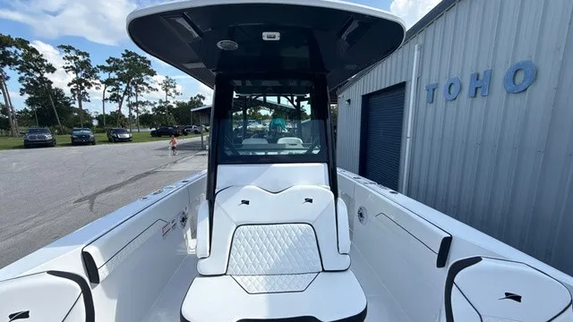 Slide: The Image of A modern 2027 Stingray 253 CC with white upholstery and black roof, parked beside a building. - 11