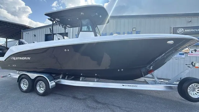 Slide: The Image of A modern 2027 Stingray 253 CC on a trailer, parked in front of a building. - 2