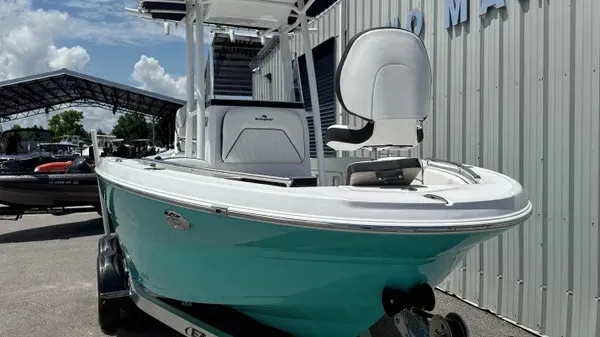 Slide: The Image of A turquoise Stingray 216 CC boat is on a trailer next to a building. - 9