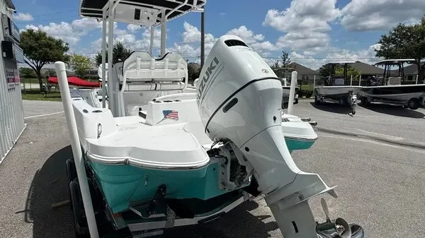 Slide: The Image of A 2027 Stingray 216 CC boat with a Suzuki outboard motor, parked on a trailer. - 6
