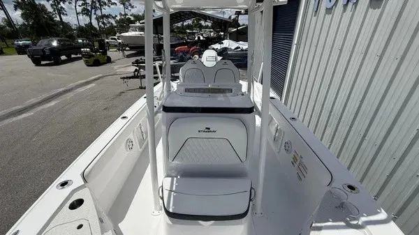 Slide: The Image of The image shows the cockpit of a 2027 Stingray 216 CC boat. It features white upholstery and a modern design. - 12