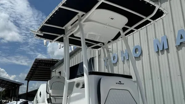 Slide: The Image of A modern boat with a white hull and black roof, situated next to a building. - 10