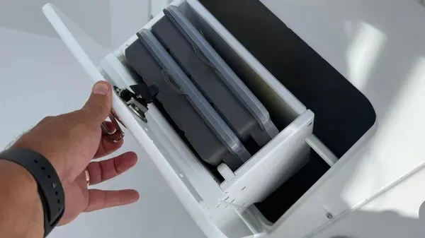 Slide: The Image of A hand opens a drawer containing two gray boxes inside. - 26