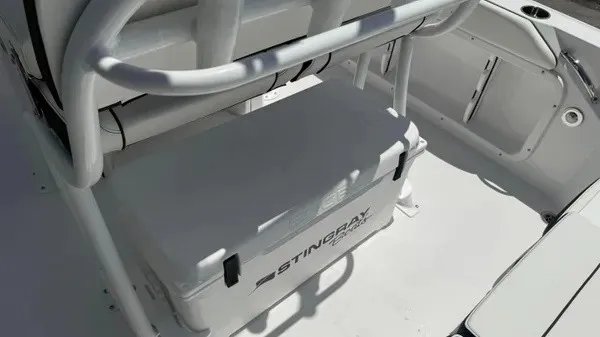 Slide: The Image of The image shows the interior of a Stingray 216 CC boat with a cooler under a seat. - 28