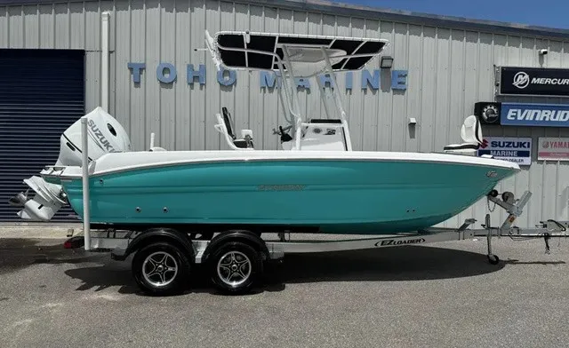 The Image of A turquoise 2027 Stingray 216 CC on a trailer in front of a building. - 1