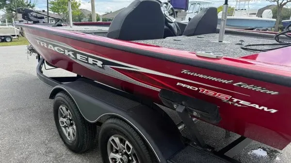 Slide: The Image of 2023 Tracker Pro Team 195 TXW Tournament Edition in red with a black trailer. - 8