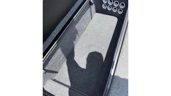Slide: The Image of An open storage compartment with gray carpeting and multiple cup holders on the side. - 13