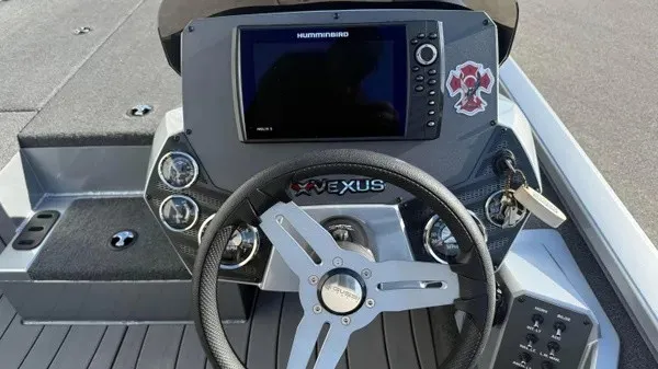 Slide: The Image of The image shows the cockpit of a 2024 Vexus AVX 1980 boat with a modern steering wheel and large display. - 12