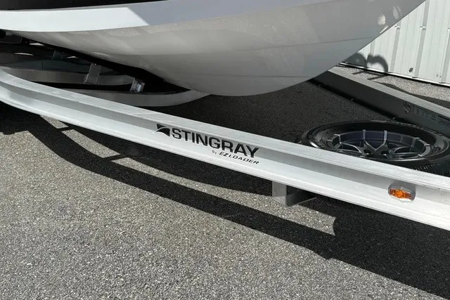 Slide: The Image of A Stingray 20 SBX boat on a trailer, partially visible, on a paved surface. - 25