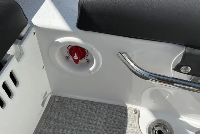 Slide: The Image of Close-up of a boat seat with black upholstery and a red switch on the side. - 15