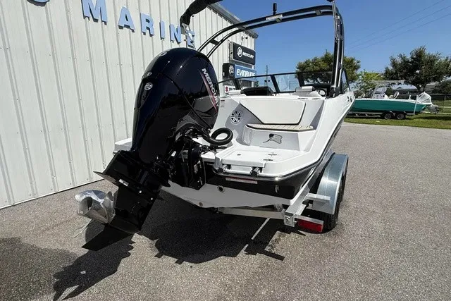 Slide: The Image of A 2027 Stingray 20 SBX boat on a trailer beside a building. - 21
