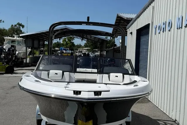 Slide: The Image of A modern 2027 Stingray 20 SBX is parked in front of a warehouse. It features a sleek design. - 26