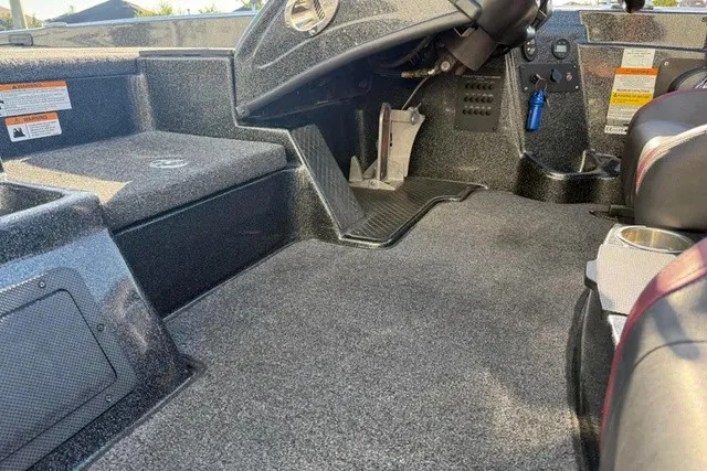 Slide: The Image of The image shows the interior of a 2019 Triton 20 TrX Patriot boat with gray carpeting. - 6